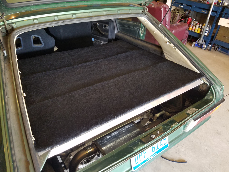 The carpeted engine cover in place, which has 22-gauge sheet aluminum panels underneath.